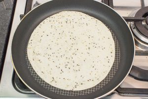Speedy Vegan Burrito – Packed with Protein - the tortilla wrap is heating up in the pan #chopped tomatoes #burrito | 