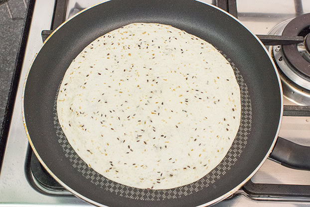 The tortilla wrap is heating up in the pan #chopped tomatoes #burrito | 
