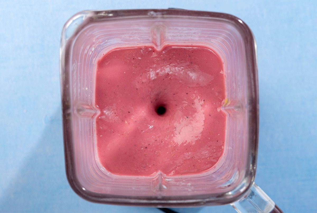A birds-eye view of a square blender, blending a smoothie on a blue table | Hurry The Food Up