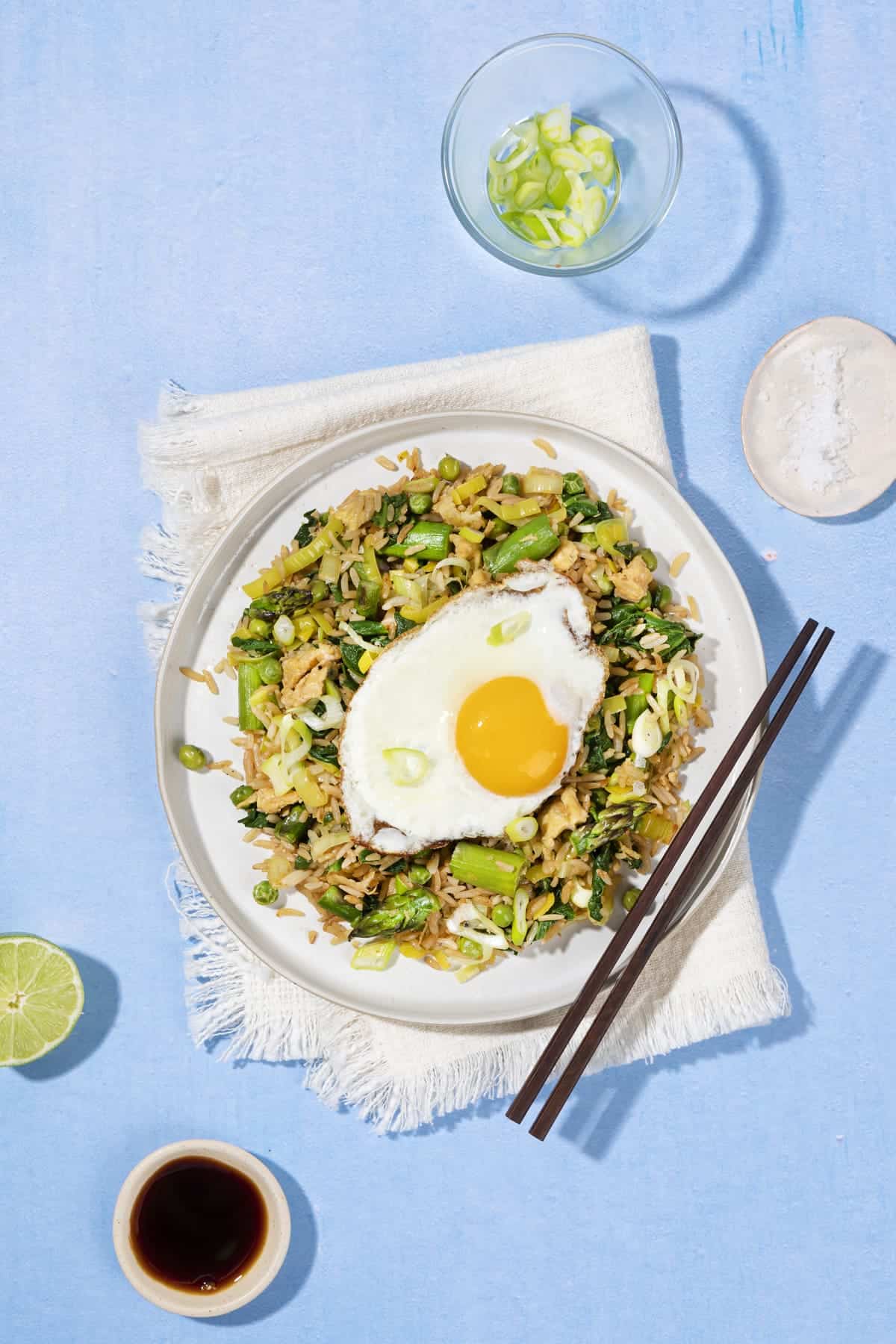 A birds eye view of a plate of fried rice with a fried egg on top and a pair of chopsticks on the side | Hurry The Food Up