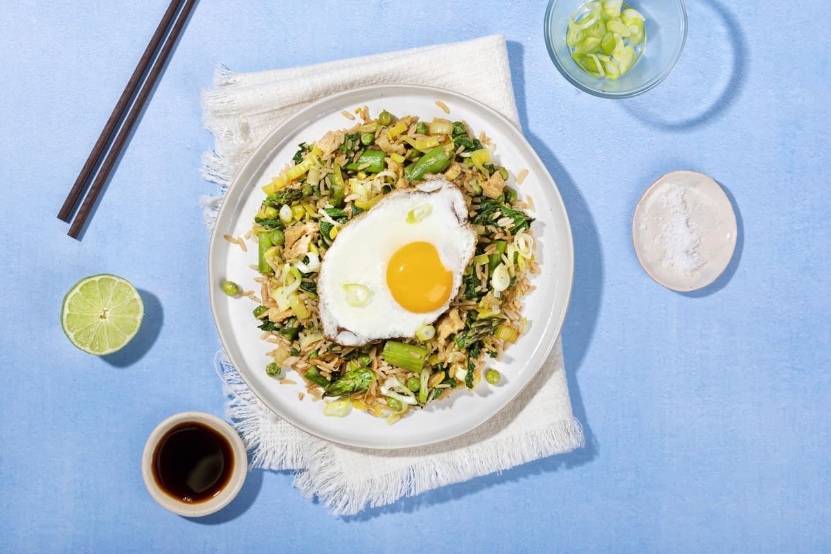 A plate of egg fried rice on a folded tea towel with half a lime, a tray of soy sauce, some spring onions| Hurry The Food Up