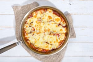 Vegetarian Moussaka is in ready in a pan that is on a grey towel | Hurry The Food Up