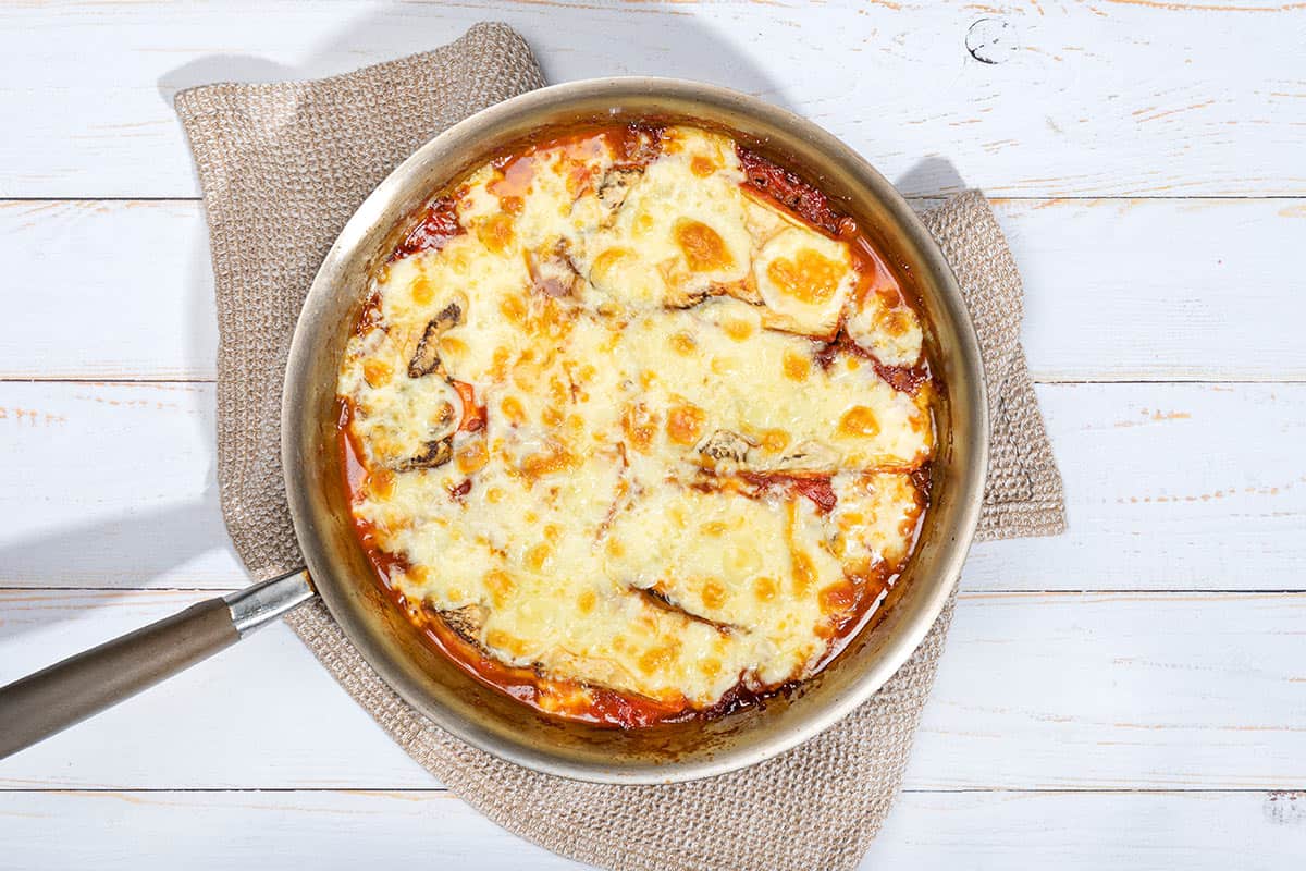 Vegetarian Moussaka is in ready in a pan that is on a grey towel | Hurry The Food Up