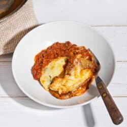 Vegetarian Moussaka is served on a plate with a pan beside it | Hurry The Food Up