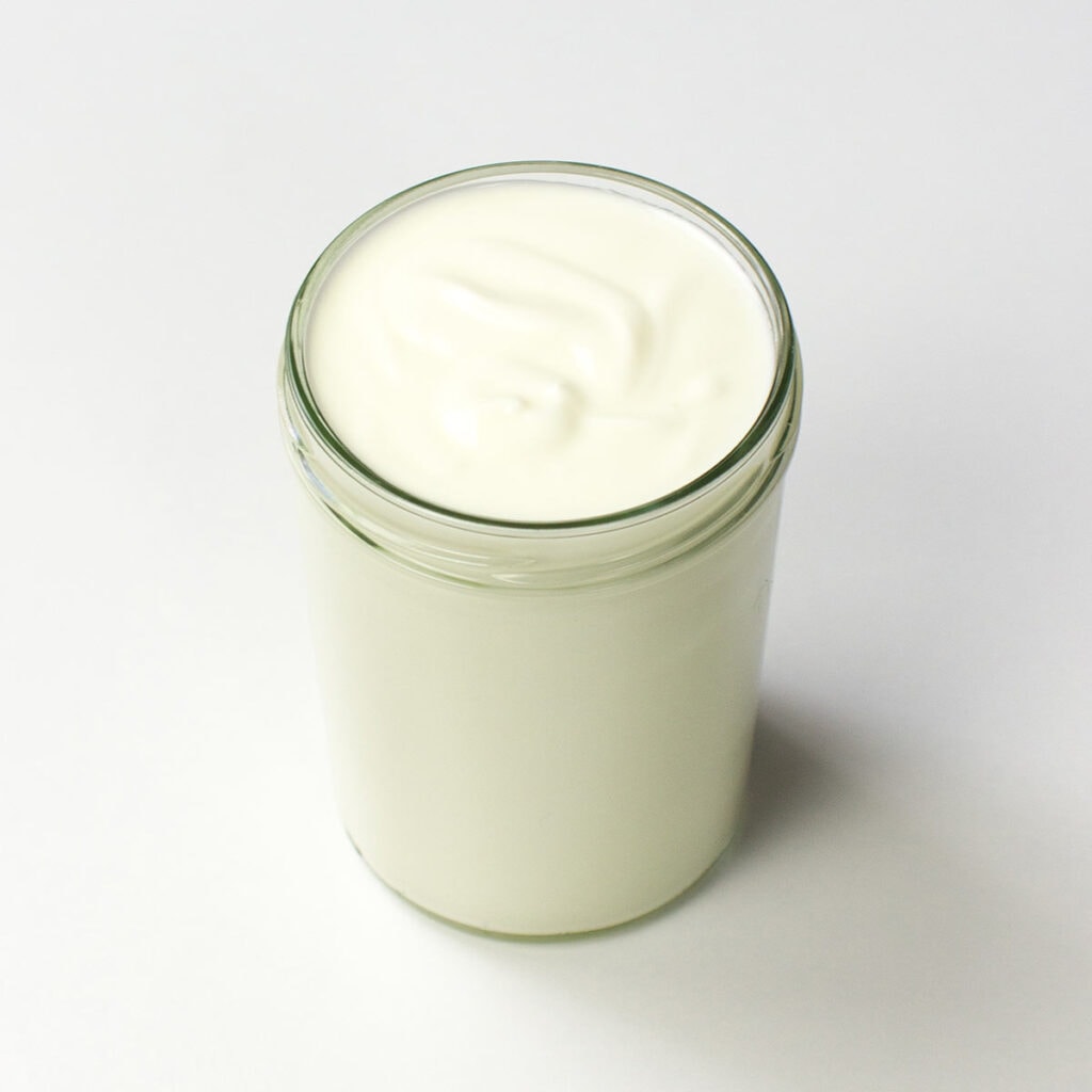 A jar of yogurt on white surface